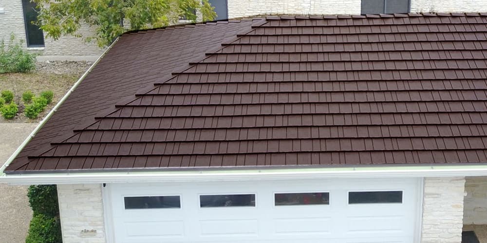 Close-up view of a brown metal shingle roof on a modern garage, showcasing its durability and aesthetic appeal.